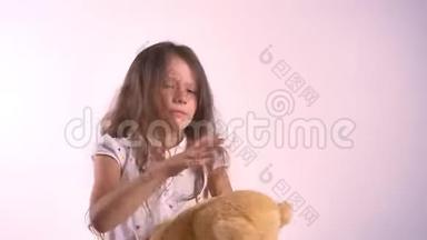 小可爱的女孩拥抱她的<strong>毛绒玩具熊</strong>，孩子拥抱玩具，孤立地站在明亮的粉红色工作室背景上
